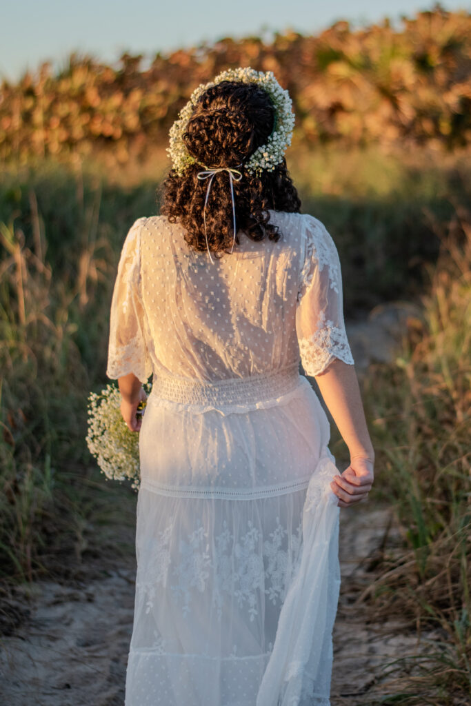 Bride walks toward the beach in Kona, Hawaii at sunset