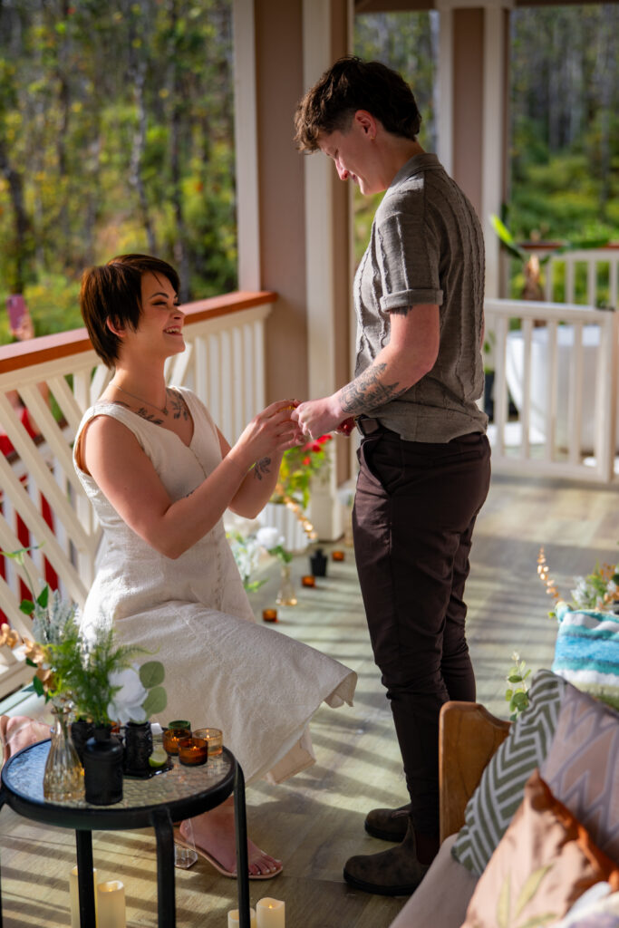A woman down on one knee proposing to another woman