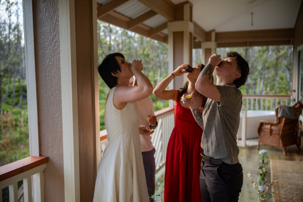 four people take a shot from black shot glasses