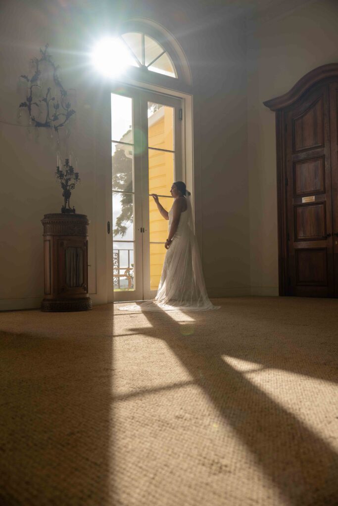 A bride looks out the window on her Parker Ranch wedding day