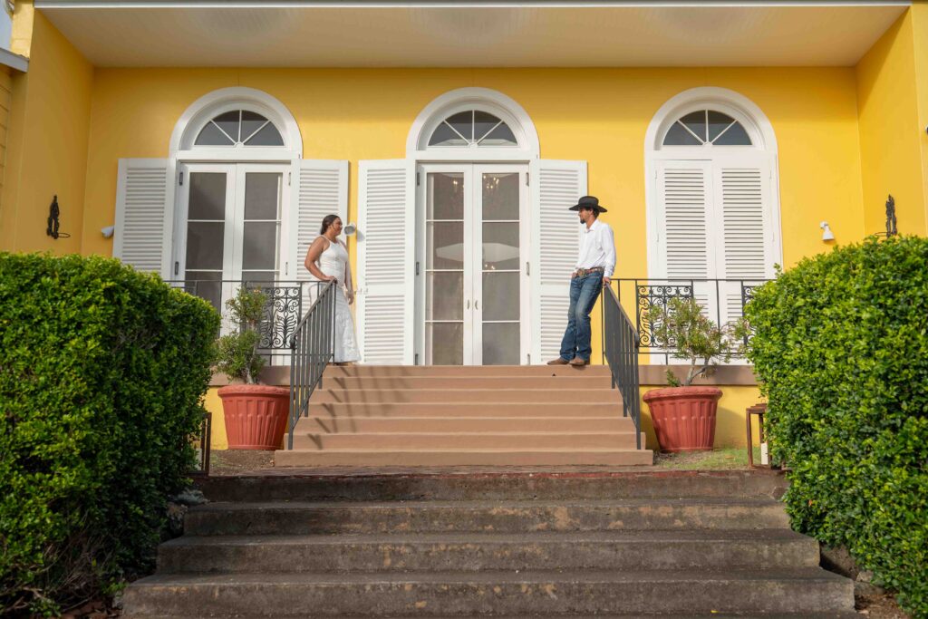 A couple stands across from each other on the Lanai at Parker Ranch headquarters