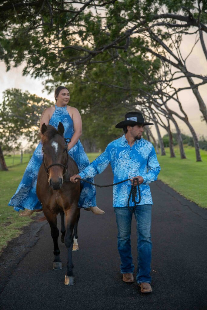 A woman sits on her horse while her husband holds the reins.