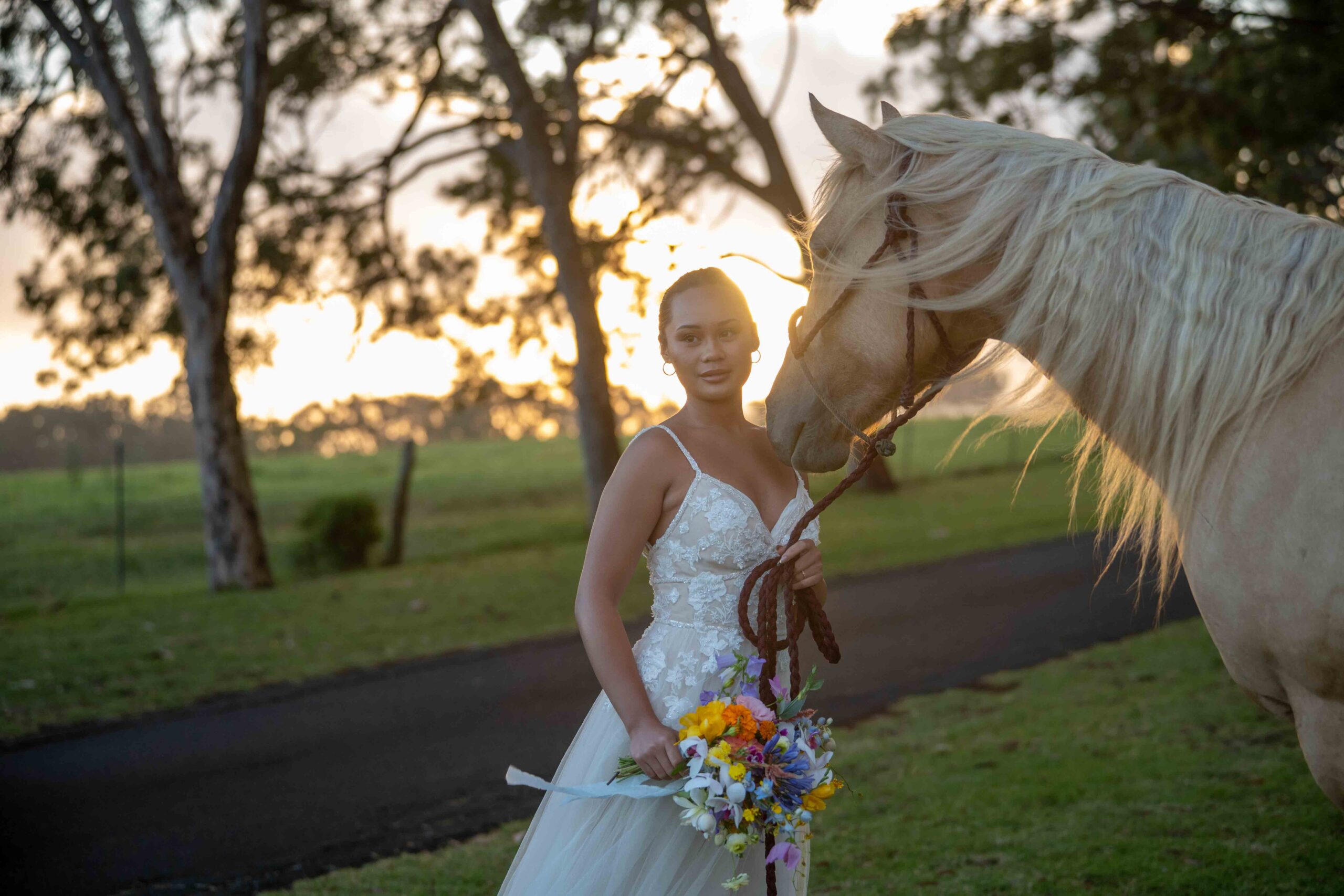 A bride stands with a horse after her Parker Ranch Wedding