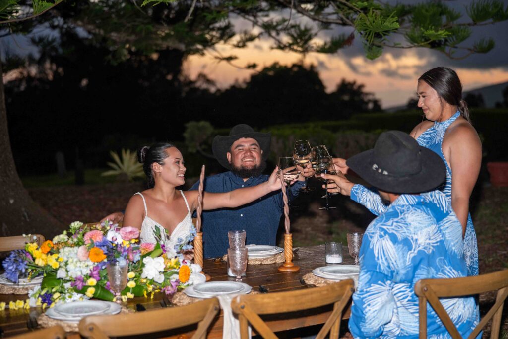 Four people have their glasses raised in a toast on a wedding day at Parker Ranch
