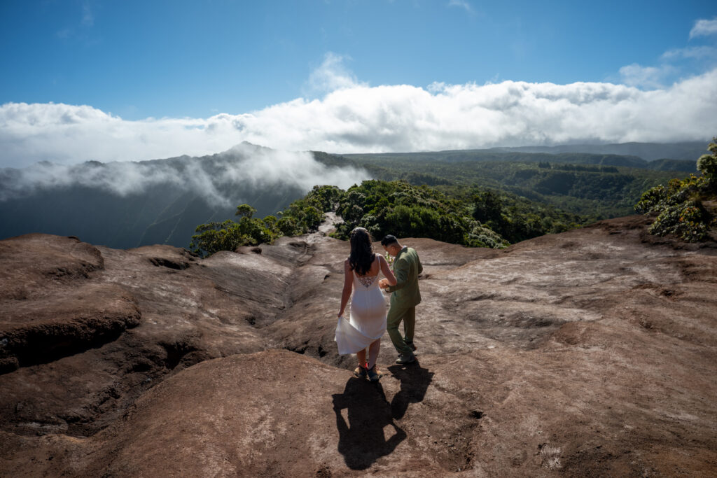 A weddingcouple hikes along the trail to Kalalau lookout for their Kauai elopement
