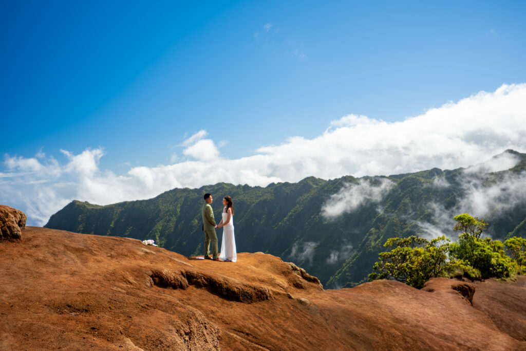 A couple stands at the edge of Kalalau lookout for their multi day Kauai elopement ceremony