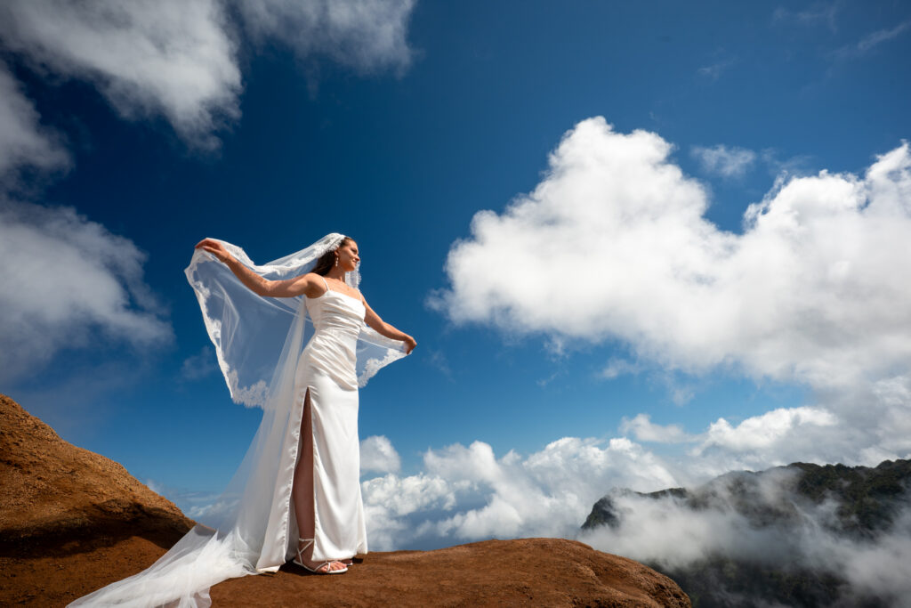 a bride poses for a portrait after her Kauai elopement at Kalalau lookout