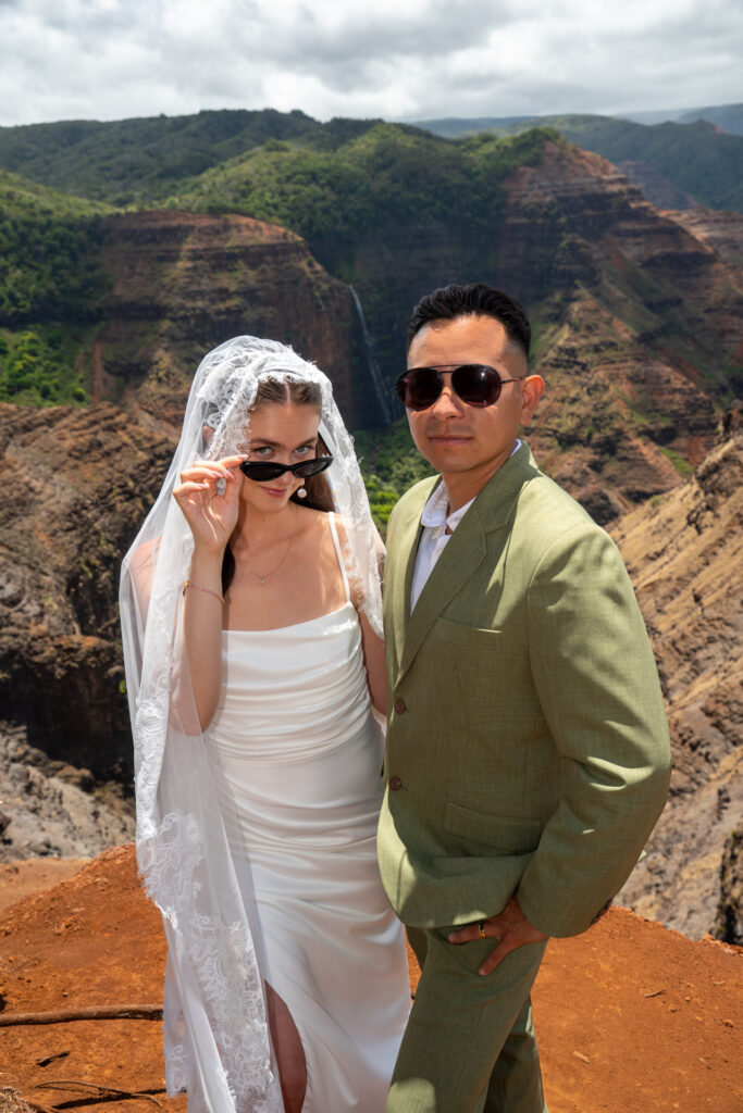 a couple poses for portraits at Waimea Canyon after their Kauai elopement