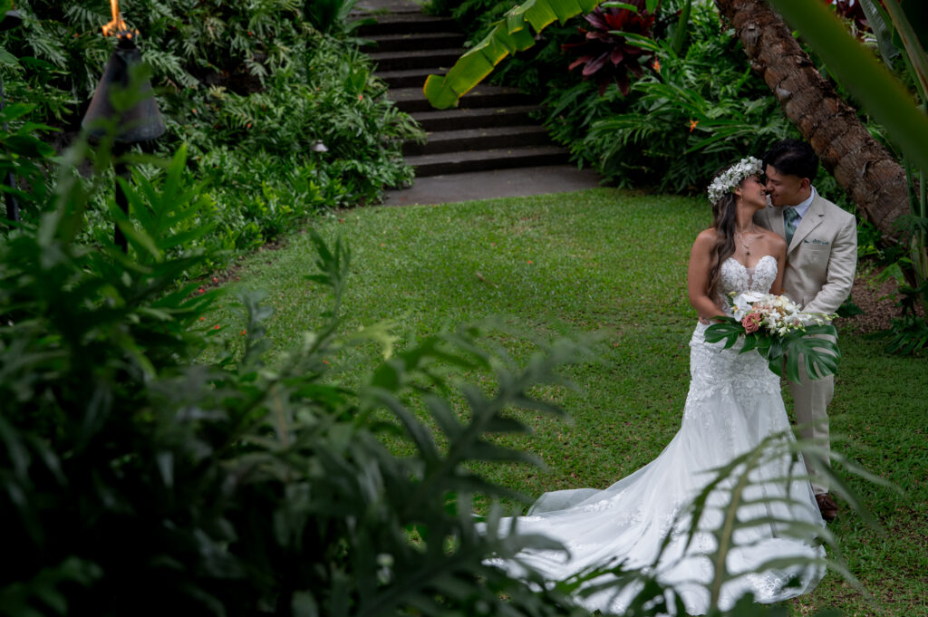 A bride and groom have a private first look in the gardens before their Outrigger Kona wedding
