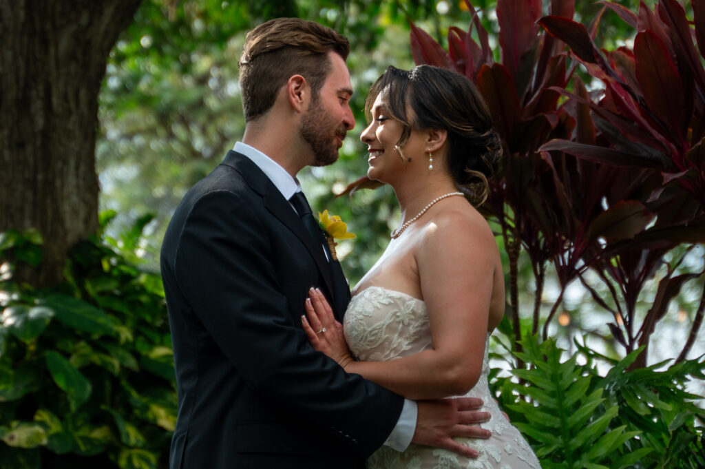 A bride and groom have a private first look in the gardens before their Outrigger Kona wedding