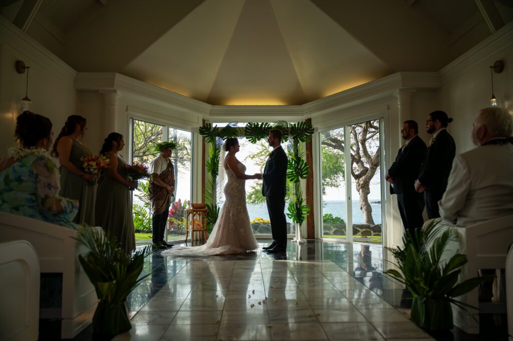 A bride and groom stand at the altar in the chapel at their Outrigger Kona wedding