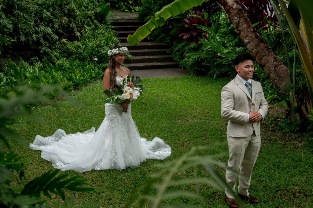 A bride and groom have a private first look in the gardens before their Outrigger Kona wedding