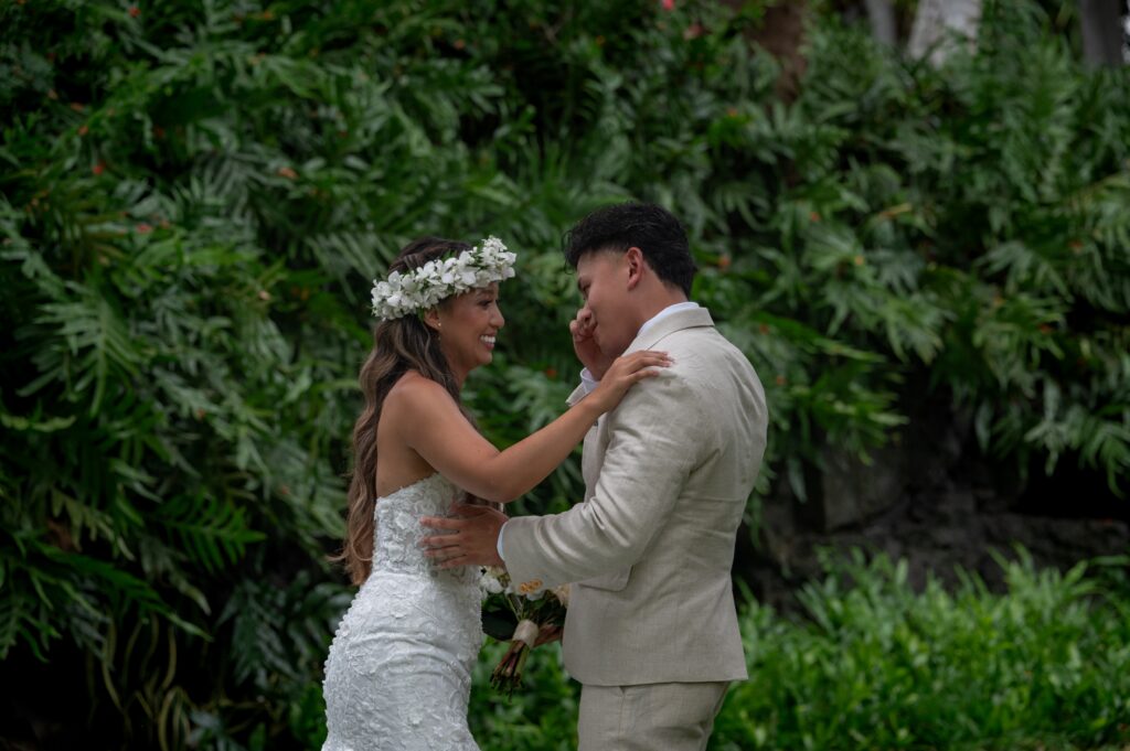 A bride and groom have a private first look in the gardens before their Outrigger Kona wedding
