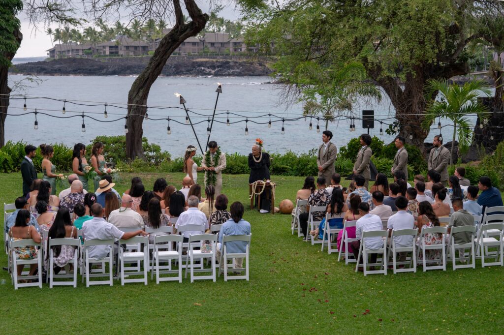 A wedding ceremony on the Bayside chapel lawn during an Outrigger Kona wedding