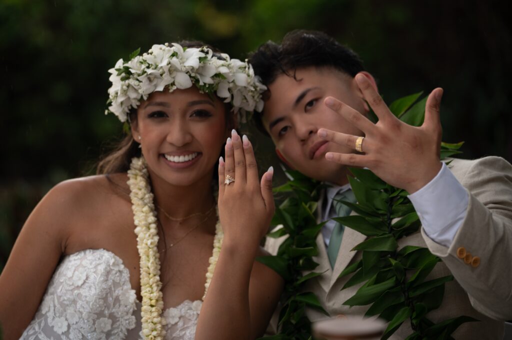 A bride and groom show off their wedding rings after their Outrigger Kona wedding ceremony