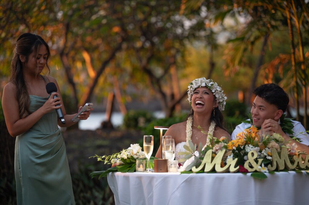 A couple sits at their sweetheart table in Helani Garden at their Outrigger Kona Wedding